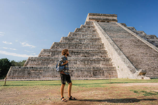 istock Man on the background of Chichen Itza pyramid in Mexico 1393589359
