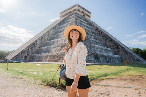 Portrait  of young Caucasian  woman  standing  on the background of Chichen Itza pyramid in Mexico