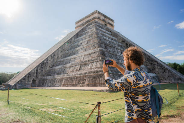 istock Man using smartphone on the background of Chichen Itza pyramid in Mexico 1393589699