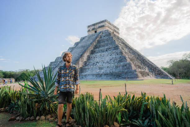 istock Man on the background of Chichen Itza pyramid in Mexico 1393591116