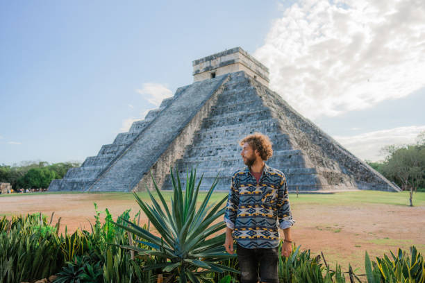 istock Man on the background of Chichen Itza pyramid in Mexico 1393591117