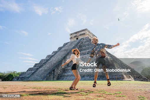 istock Couple on the background of Chichen Itza pyramid in Mexico 1393591298