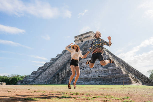 istock Couple on the background of Chichen Itza pyramid in Mexico 1393591299