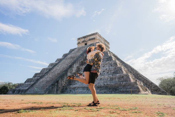 Couple on the background of Chichen Itza pyramid in Mexico Young Caucasian  heterosexual couple on the  background of Chichen Itza pyramid in Mexico valladolid mexico photos stock pictures, royalty-free photos & images