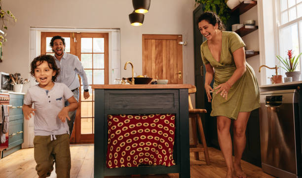 istock Playful parents chasing after their son in the kitchen 1393591881