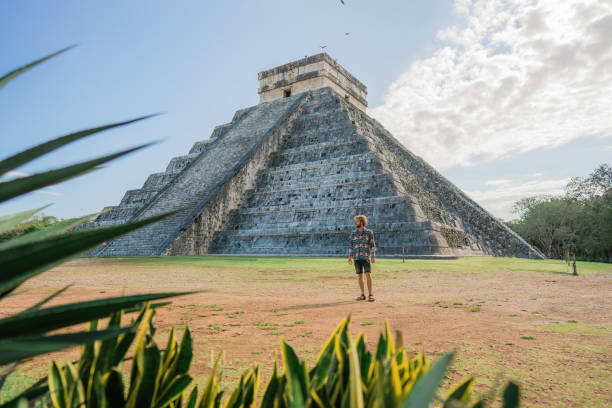 istock Man on the background of Chichen Itza pyramid in Mexico 1393595262