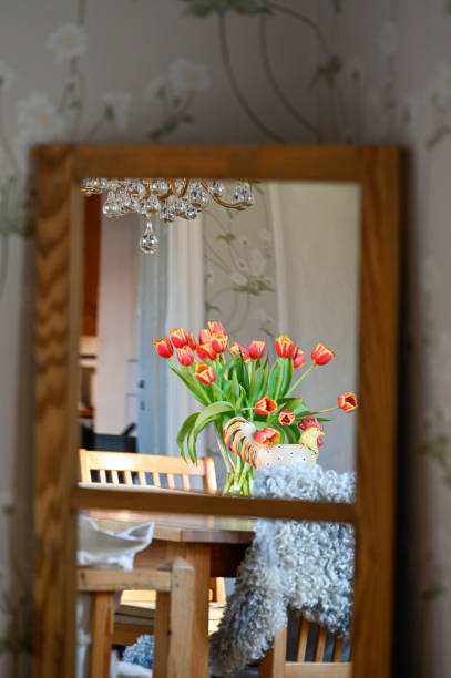 istock Vase with tulips standing on tabel seen through mirror 1393595290