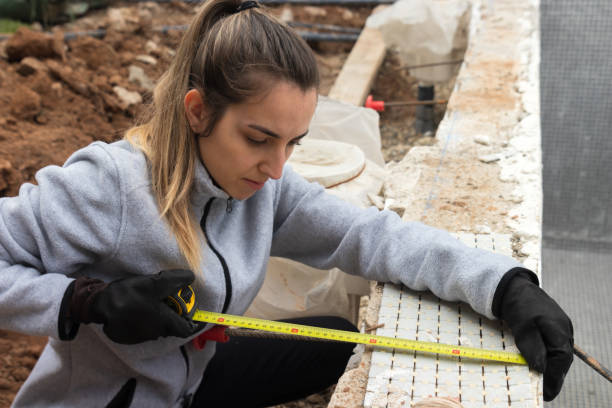 Woman building with her own hands a pool for her house and measuring Woman building with her own hands a pool for her house and measuring with a meter some tiles for the walls yard measurement stock pictures, royalty-free photos & images