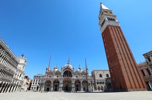 Piazza San Marco in Venice in Italy with very few people with the basilica in the background and the high bell tower in the almost deserted square