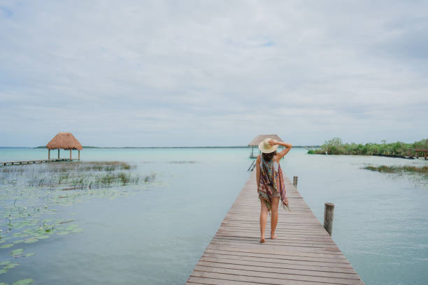istock Woman walking on pier on Bacalar Lagoon 1393595693