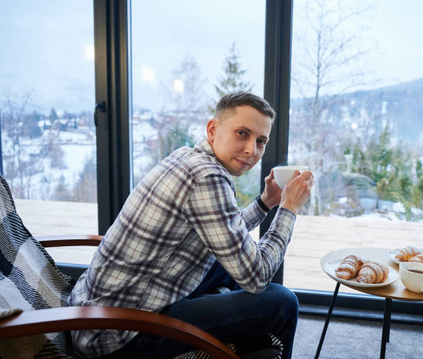 istock Man enjoying weekends inside contemporary cottage. 1393598861