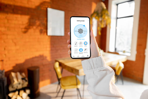 istock Woman holding phone with running smart home application 1393601755