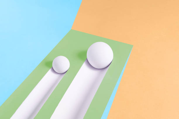 istock Two white balls roll downhill and leave a trail on a multicolor background 1393609584