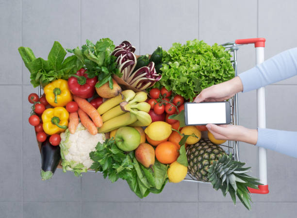 istock Woman buying fresh greens and using her smartphone 1393615178