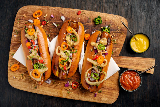 artisan hot dogi w brioche rolls z marynatami, cebulą i smakołykami. - hot dog snack food ketchup zdjęcia i obrazy z banku zdjęć