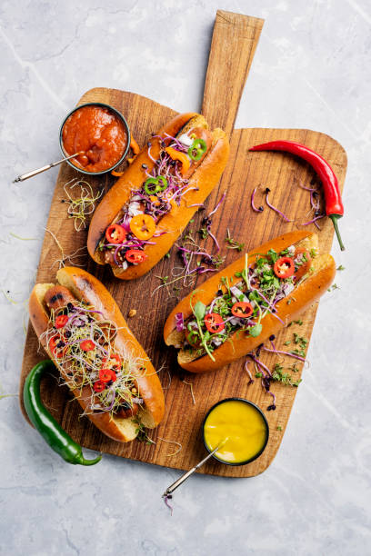 вегетарианские хот-доги в булочках brioche с солеными огурцами, луком и лакомствами. - hot dog snack food ketchup стоковые фото и изображения