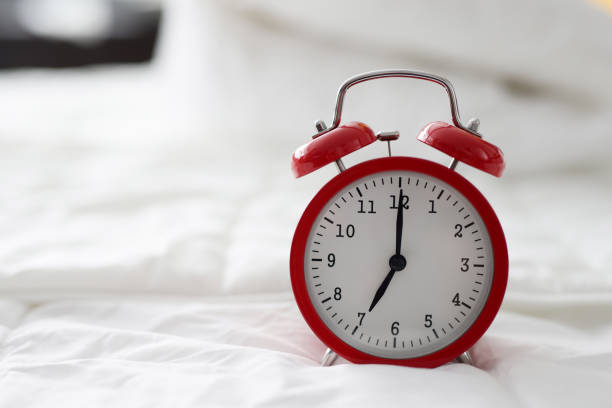 istock Red alarm clock at 7 oclock on bed 1393619534