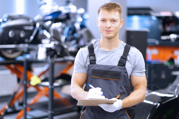istock Smiling mechanic, maintenance service worker in uniform, man with clipboard paper 1393619575
