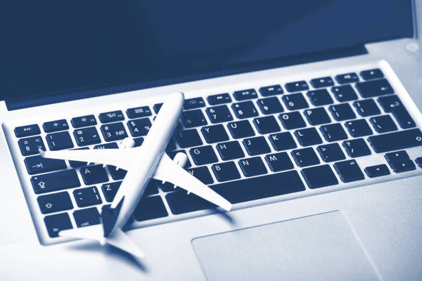 istock Plane on laptop keyboard. Booking tickets online Blue tone 1393619941