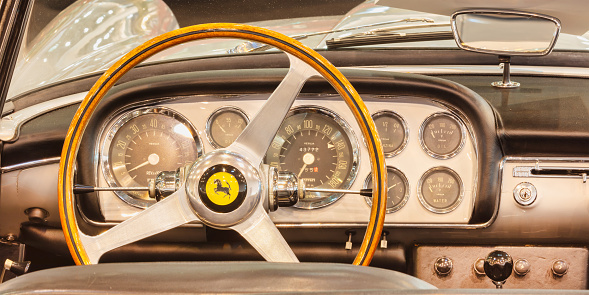 Essen, Germany - March 23, 2022: Interior of a classic Ferrari sports car with wooden steering wheel in Essen, Germany