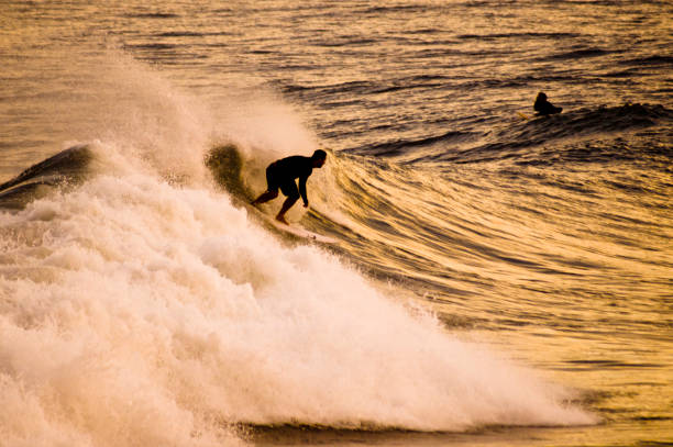 Surfer dropping in a left wave at the Joaquina Beach. Florianópolis, State of Santa Catarina, Brazil. April 12, 2022.
