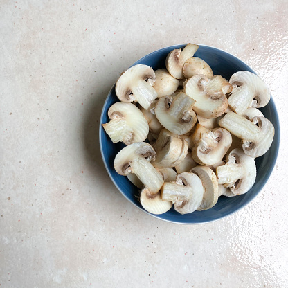 High angle view of fresh chopped edible mushroom in a bowl in the kitchen as healthy food ingredient.