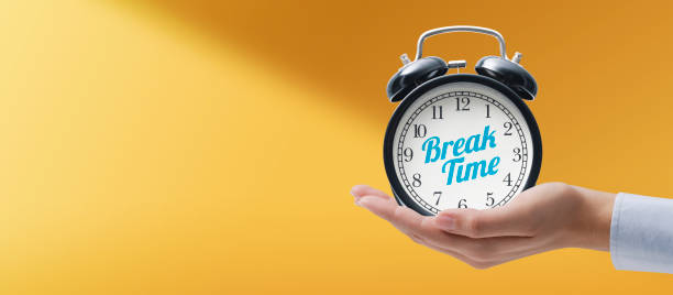 istock Hand holding a vintage alarm clock with break time message 1393623820
