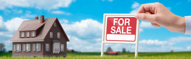 Property for sale and real estate agent holding a sign stock photo