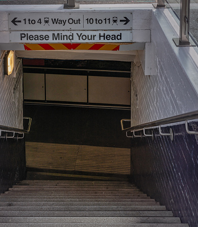 York, UK. April 14, 2022. Entrance to a station subway. Steps lead down to a passage and signs are overhead.