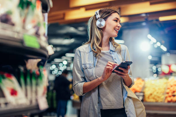 istock Woman using technology while buying groceries in market 1393629883