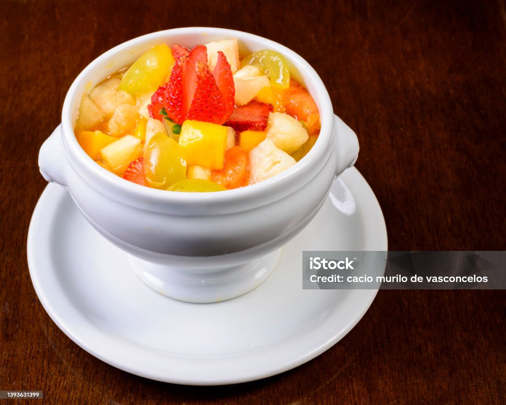 Fruit salad with strawberry, green grape, mango and pineapple. Served in a white bowl. Antioxidant Stock Photo