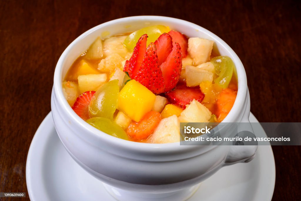 Fruit salad with strawberry, green grape, mango and pineapple. Served in a white bowl. Antioxidant Stock Photo