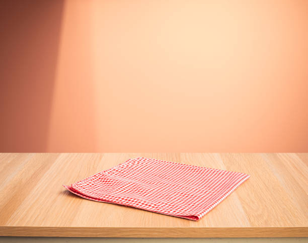 istock Red fabric,cloth on wood table top on color wall background. 1393631553