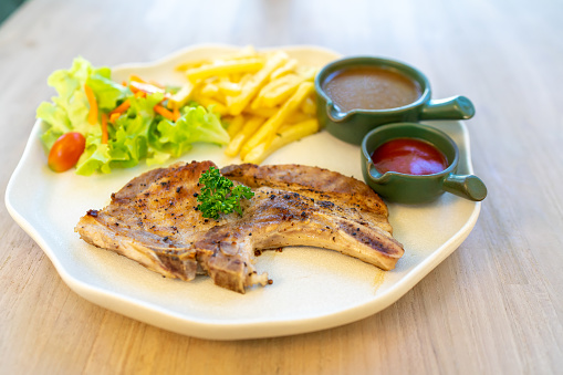 Grilled steaks served with vegetables fre-fried and ketchup