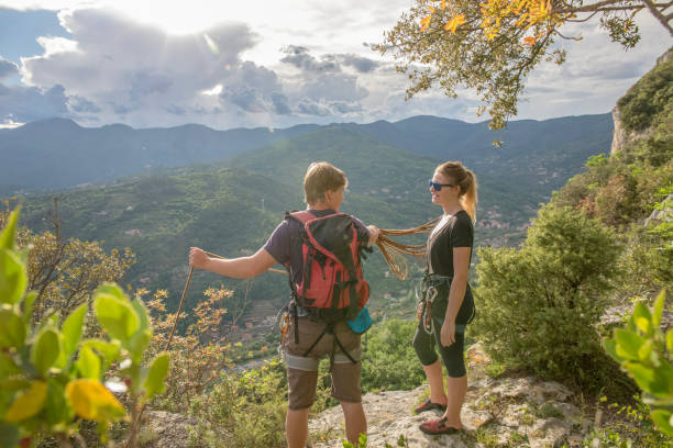 wspinający się przyjaciele stoją na klifie nad doliną - hiking young women outdoors t shirt zdjęcia i obrazy z banku zdjęć