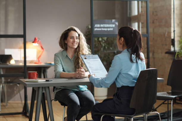 mulher apresentando seu currículo em entrevista - resume hire job applying - fotografias e filmes do acervo