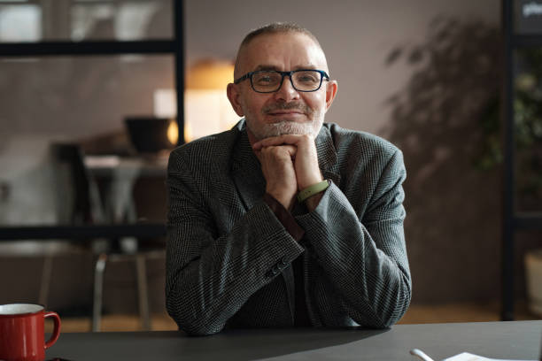 istock Satisfied mature businessman sitting at office 1393636077