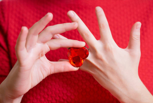 istock Lady in red puts a huge heart shaped ring on finger 1393638971