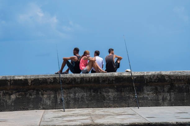 Fishing on El Malecon seawall in Havana. stock photo