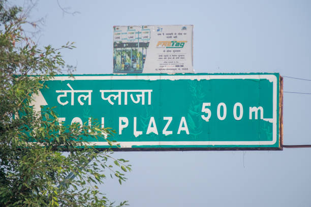 Delhi, India - circa 2021: Congested traffic jam cars in front of a toll booth showing the new RFID based payment system FASTag along with the logo for the national highway authority of India NHAI