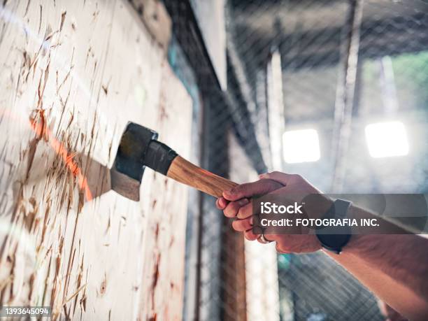 Young Gay Man Throwing Axe At The Game Range Stock Photo - Download Image Now - Axe Throwing, Axe, Throwing
