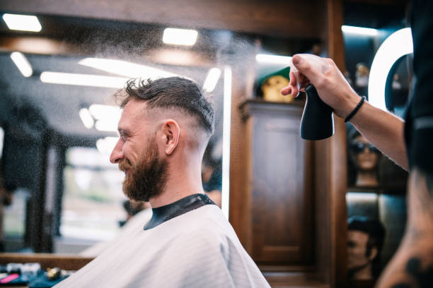 istock Hairdresser using spay on customer hair. 1393646066