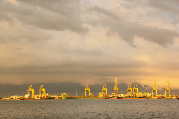 Georgetown, Penang, Malaysia - November 2012: Yellow oil rigs under an cloudy sky above the water off the coast of George Town in Penang.