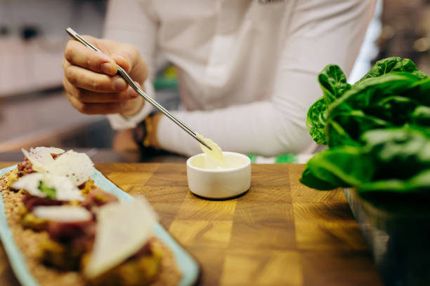 istock Chief chef serving snacks, canapes or sandviches adding finishing touch on dish before it is going to be served for restaurant guests 1393651298