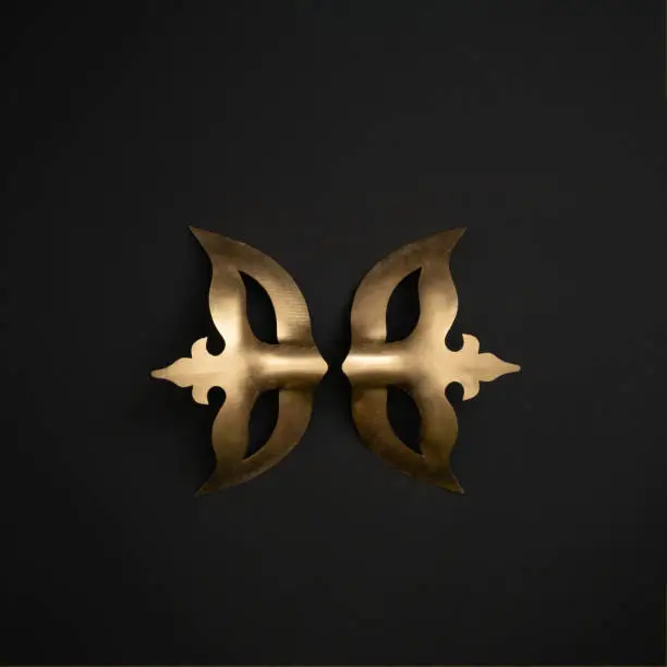 Two metallic gold masquerade masks on black background. Carnival or Masquerade concept.