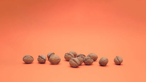 istock Ripe walnuts isolated on apricot background. Food concept. 1393656418