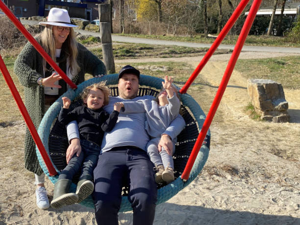 istock Young family in swing set 1393656474