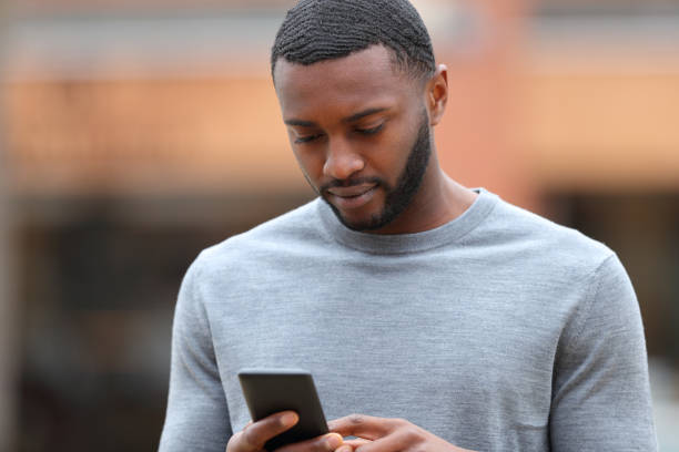 istock Man with black skin is using smart phone 1393657820