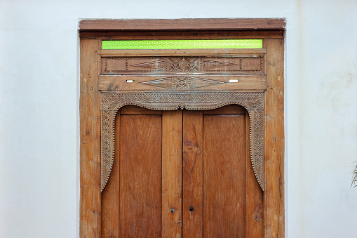 An ornately carved vintage wooden door frame of a house in the heritage town of Georgetown in Penang, Malaysia.