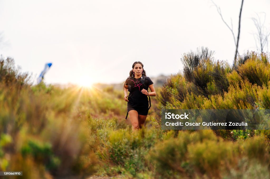 latin young woman doing trail running Cross-Country Running Stock Photo